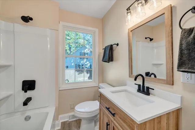 a bathroom with a sink toilet a mirror and shower
