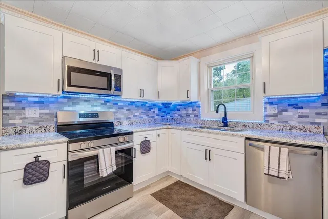 a kitchen with stainless steel appliances granite countertop a sink stove and microwave