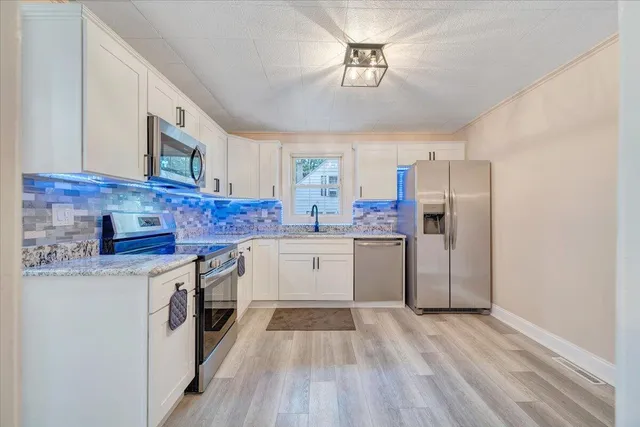 a kitchen with stainless steel appliances granite countertop a stove a sink dishwasher and a refrigerator