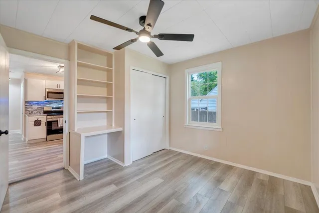 a view of a livingroom with wooden floor closet and windows
