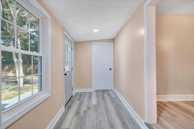 a view of hallway with a large window and wooden floor