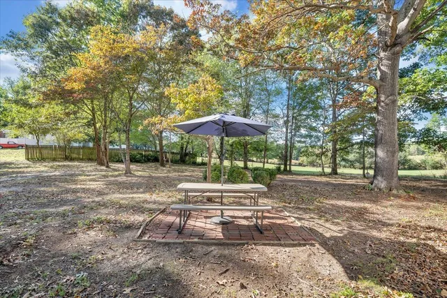 a backyard of a house with table and chairs