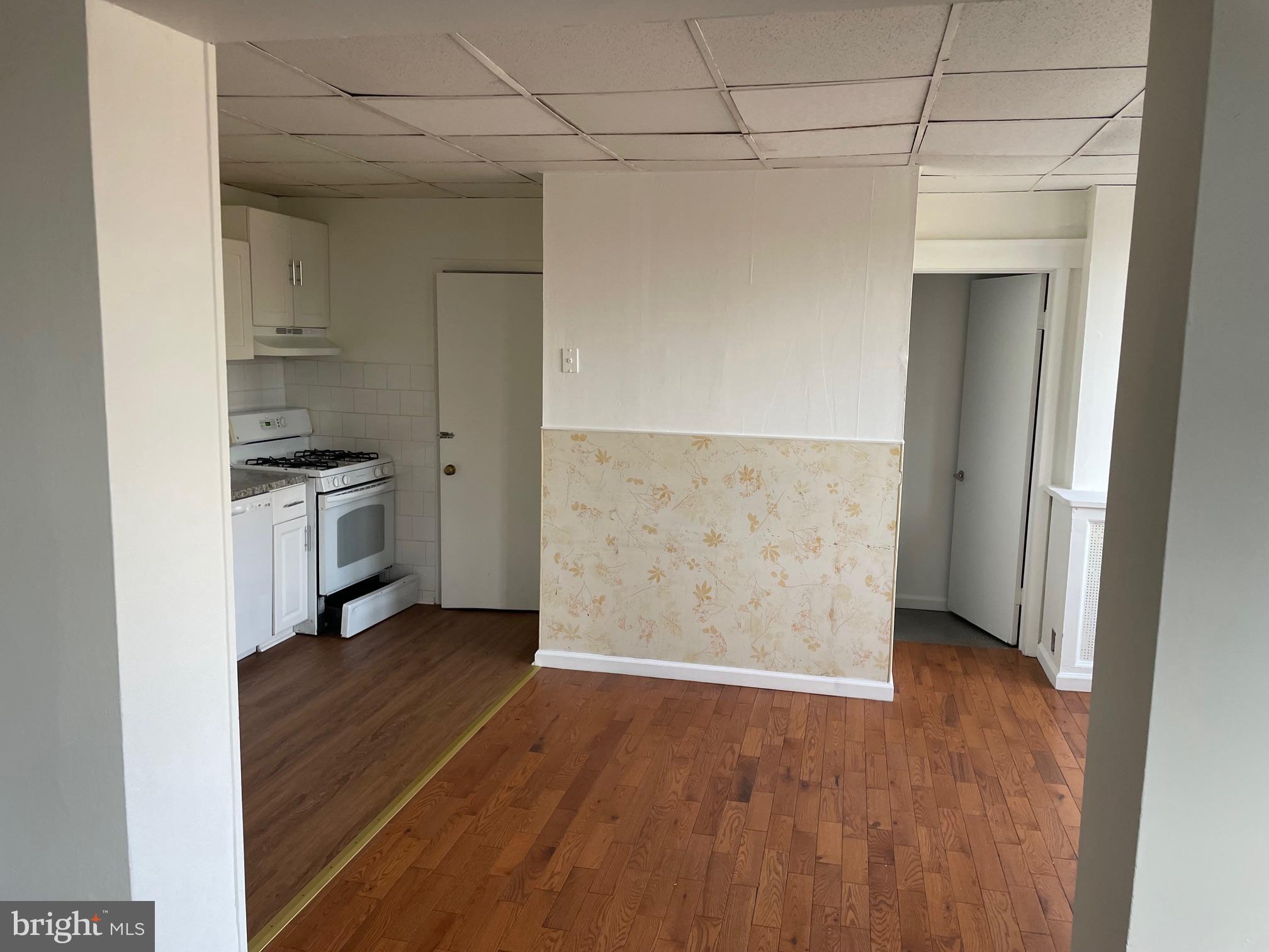 542 East State Street Trenton, NJ 08609 - Photo 3 of 4 an empty room with wooden floor cabinet and a hallway