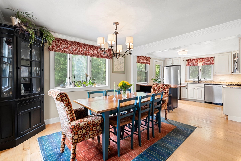 35 Spallus Road Stoughton, MA 02072 - Photo 16 of 39 a dining room with furniture a chandelier and wooden floor