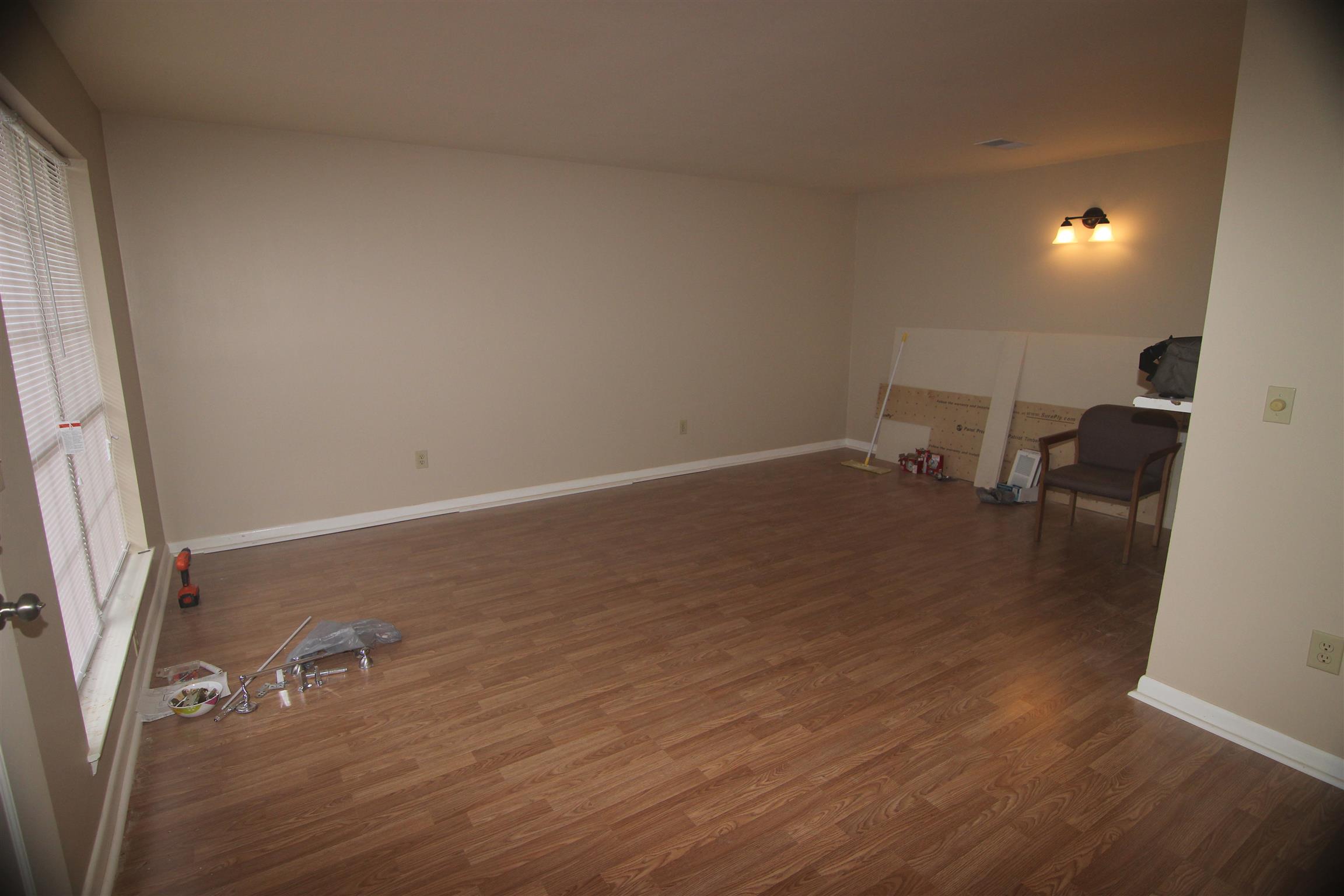 1245 Old Lascassas Road, Unit F Murfreesboro, TN 37130 - Photo 3 of 9 an empty room with wooden floor and a chair