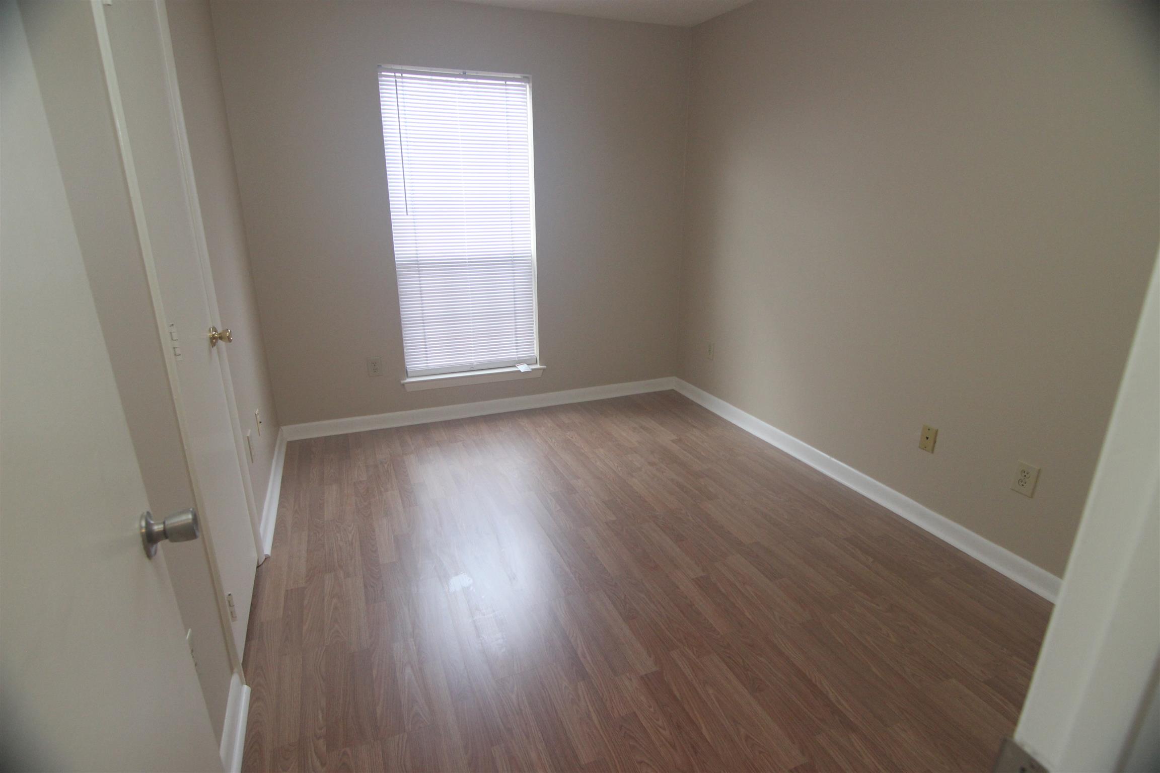 1245 Old Lascassas Road, Unit F Murfreesboro, TN 37130 - Photo 6 of 9 a view of an empty room with wooden floor and a window