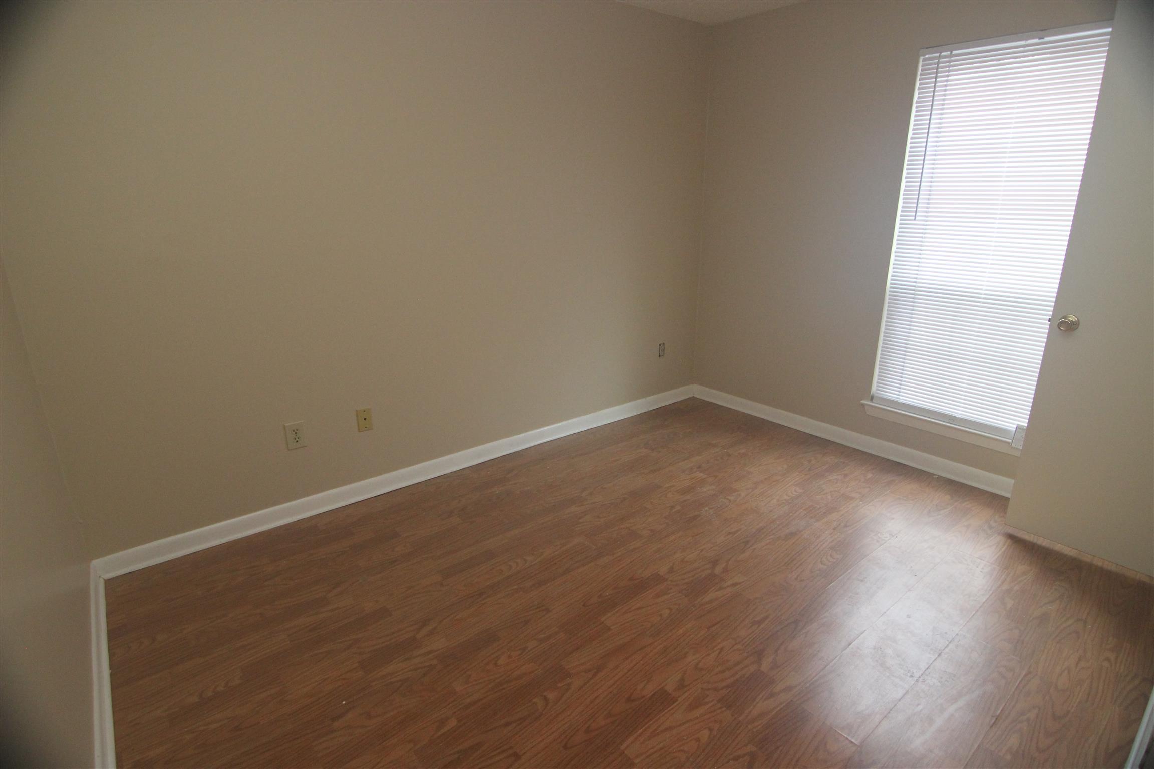 1245 Old Lascassas Road, Unit F Murfreesboro, TN 37130 - Photo 7 of 9 an empty room with wooden floor and windows