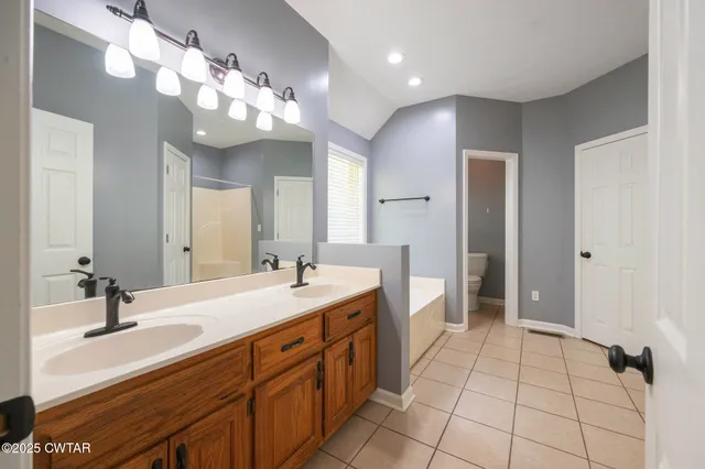 a spacious bathroom with a double vanity sink a mirror and a shower