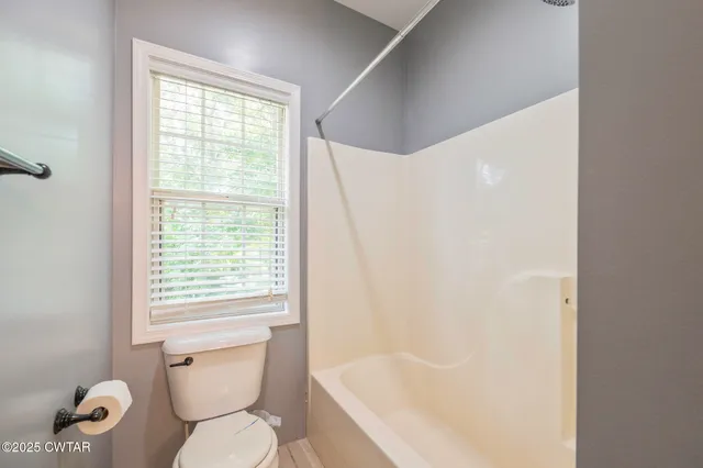 a white toilet sitting next to a bath tub