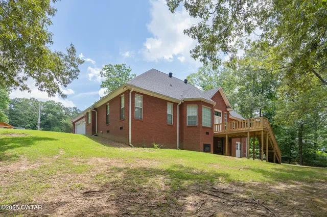 a front view of a house with a garden and trees