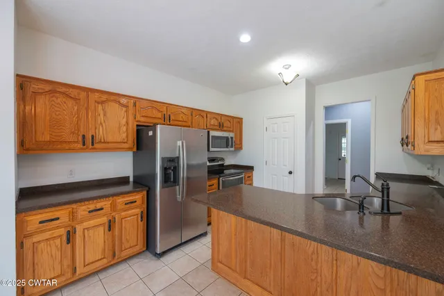 a kitchen with stainless steel appliances granite countertop a sink refrigerator and cabinets
