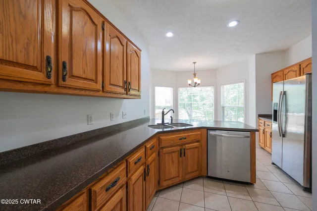a kitchen with stainless steel appliances granite countertop a sink a stove and a refrigerator