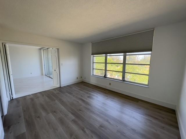 2650 South Course Drive, Unit 603 Pompano Beach, FL 33069 - Photo 9 of 25 an empty room with wooden floor and windows