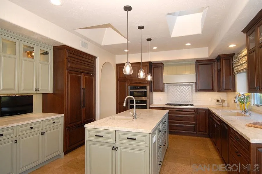 6515 Poco Lago Rancho Santa Fe, CA 92091 - Photo 5 of 25 a kitchen with a sink stainless steel appliances and cabinets