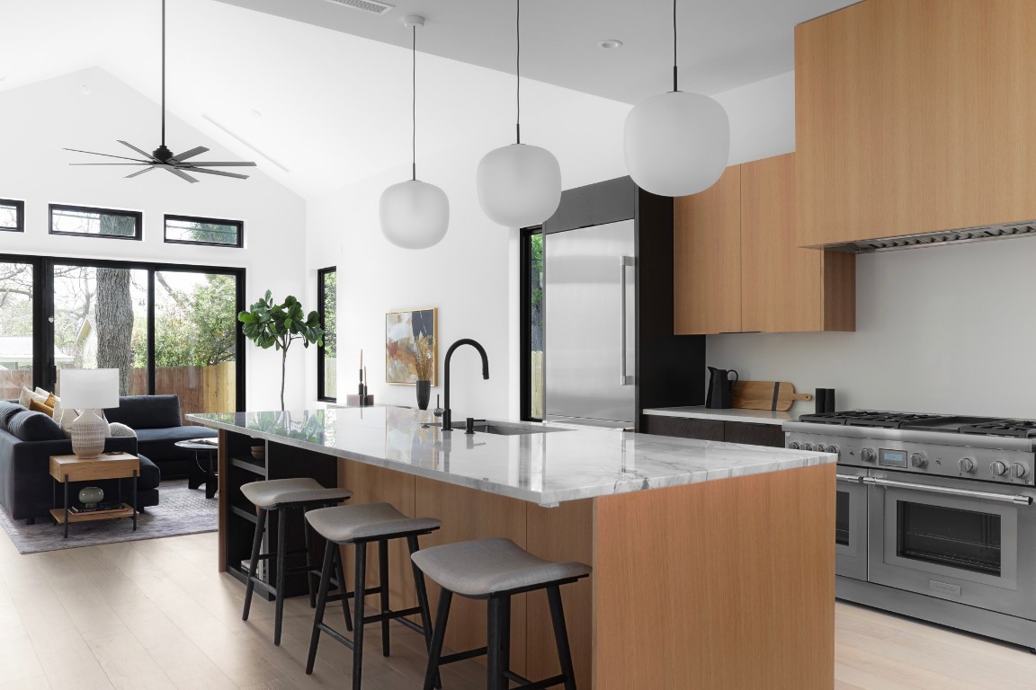 1701 Pasadena Drive Austin, TX 78757 - Photo 1 of 1 a kitchen with stainless steel appliances granite countertop a stove a sink dishwasher a dining table and chairs with wooden floor