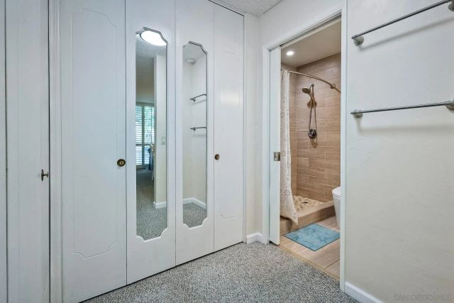 a bathroom with a granite countertop toilet sink and mirror