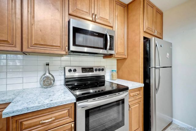a kitchen with stainless steel appliances granite countertop a stove microwave and refrigerator