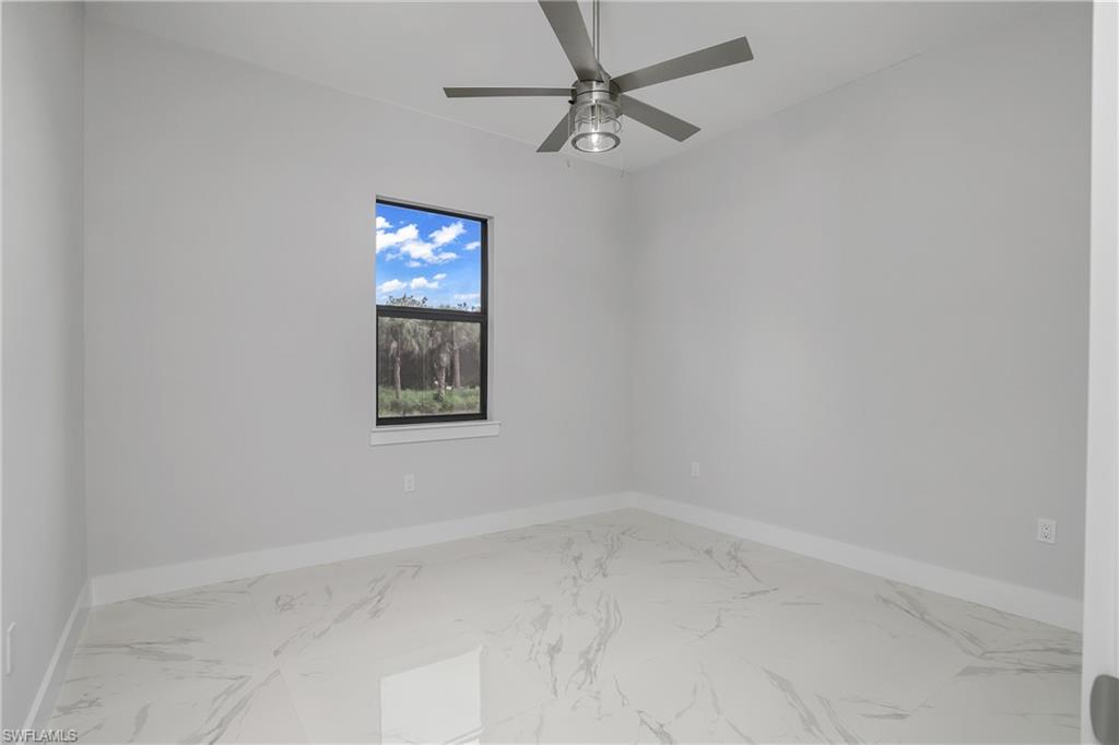 791 14th Street Northeast Naples, FL 34120 - Photo 19 of 46 Spare room featuring marble look tile flooring and a ceiling fan