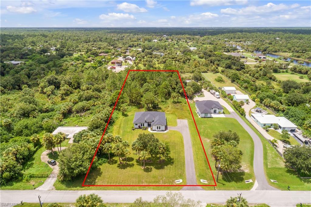 791 14th Street Northeast Naples, FL 34120 - Photo 3 of 46 Aerial view of residential area with property boundaries highlighted and a nearby body of water