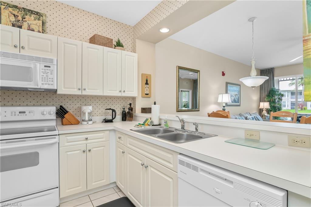 791 14th Street Northeast Naples, FL 34120 - Photo 46 of 46 Kitchen with white appliances, hanging light fixtures, light countertops, open floor plan, and light tile patterned flooring
