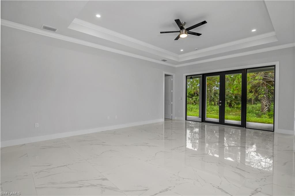 791 14th Street Northeast Naples, FL 34120 - Photo 5 of 46 Empty room with ceiling fan, crown molding, french doors, light marble finish flooring, and recessed lighting