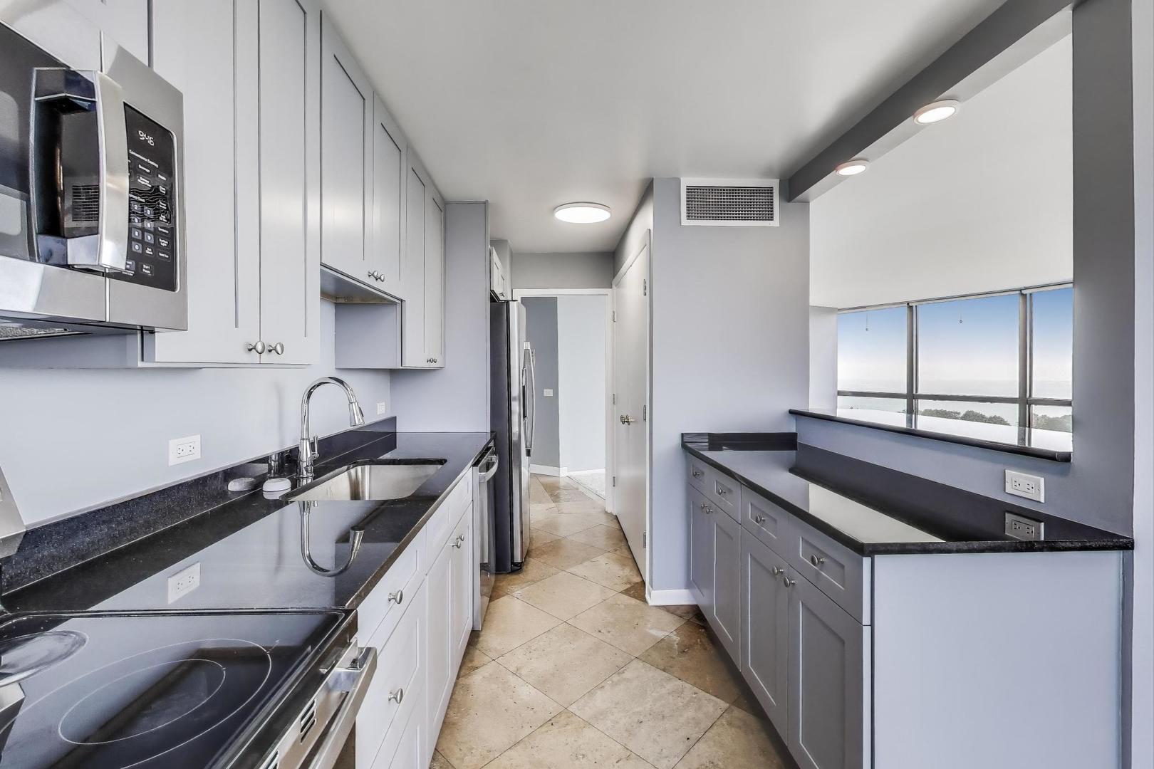 5415 North Sheridan Road, Unit 1401 Chicago, IL 60640 - Photo 15 of 46 a kitchen with a sink stove and cabinets