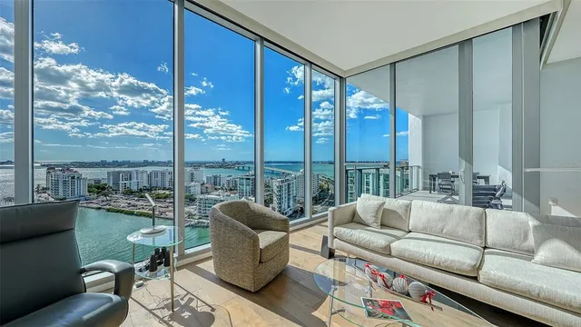 a living room with furniture and a view of kitchen