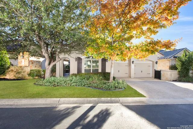 a view of a white house with a yard and large tree