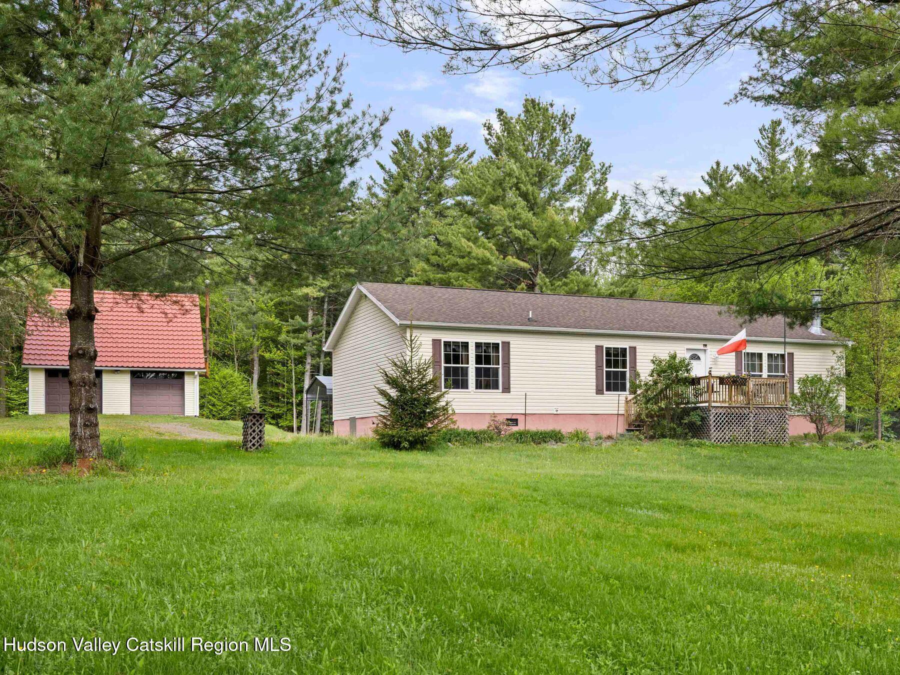 137 Mountain Pond View Road Gilboa, NY 12076 - Photo 1 of 38 a front view of a house with a garden and trees