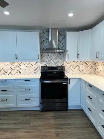 a kitchen with stainless steel appliances granite countertop a stove and a wooden cabinets