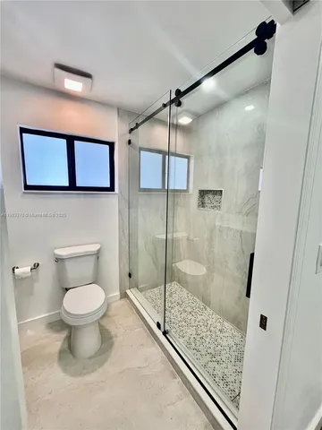 a bathroom with a toilet and a shower