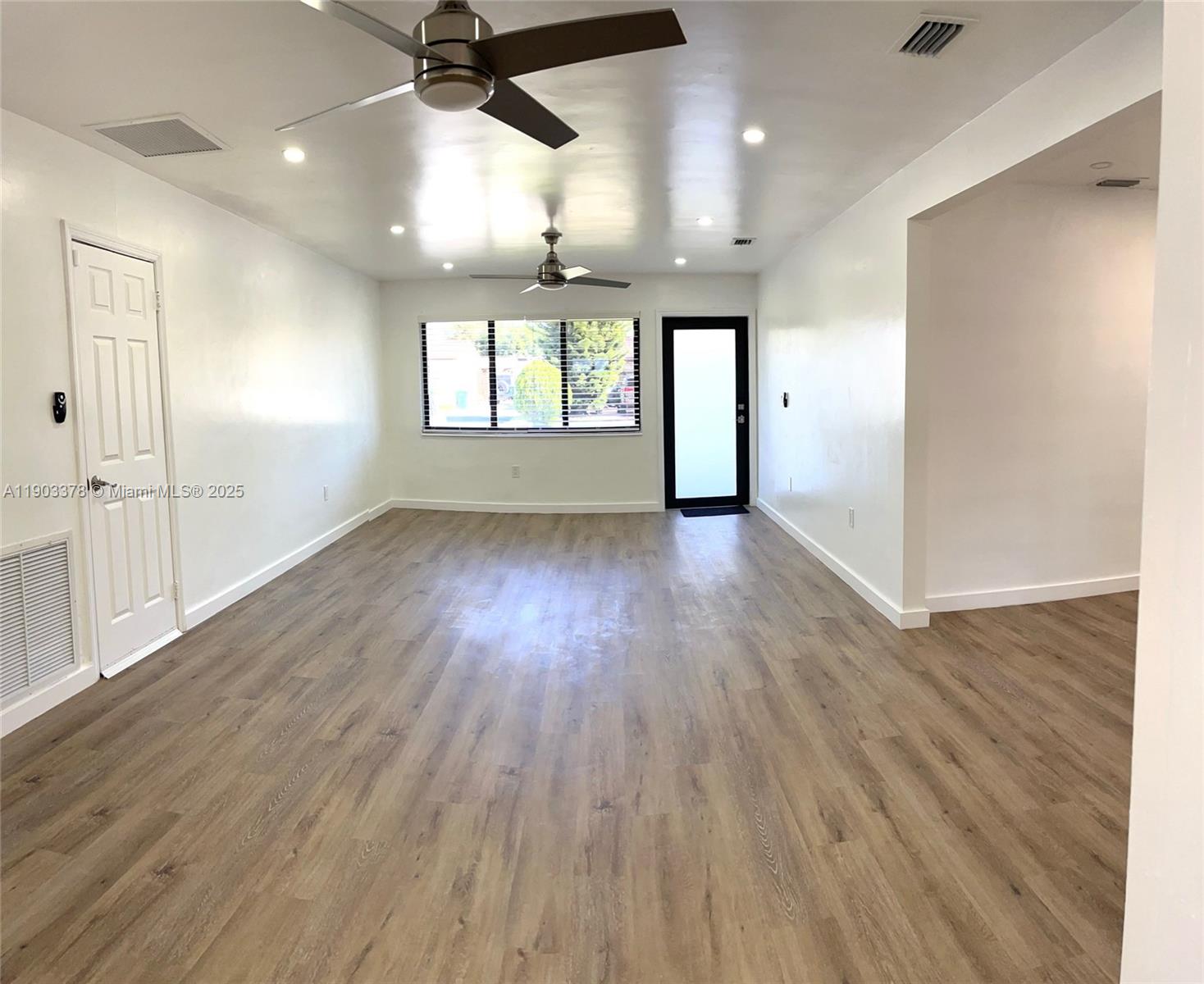 4640 Southwest 94th Court Miami, FL 33165 - Photo 6 of 37 an empty room with wooden floor and windows