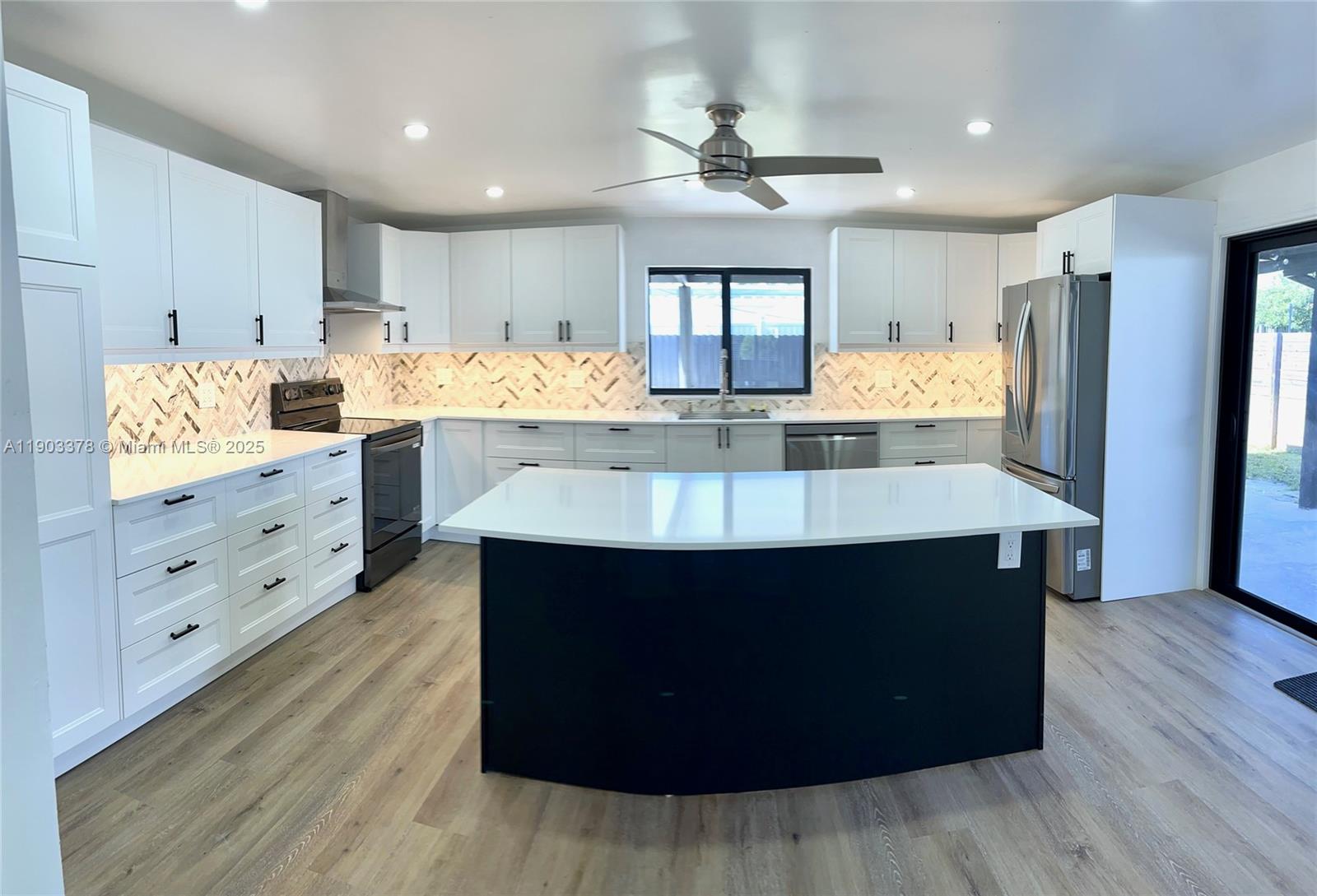 4640 Southwest 94th Court Miami, FL 33165 - Photo 8 of 37 a kitchen with kitchen island granite countertop a sink cabinets and wooden floor