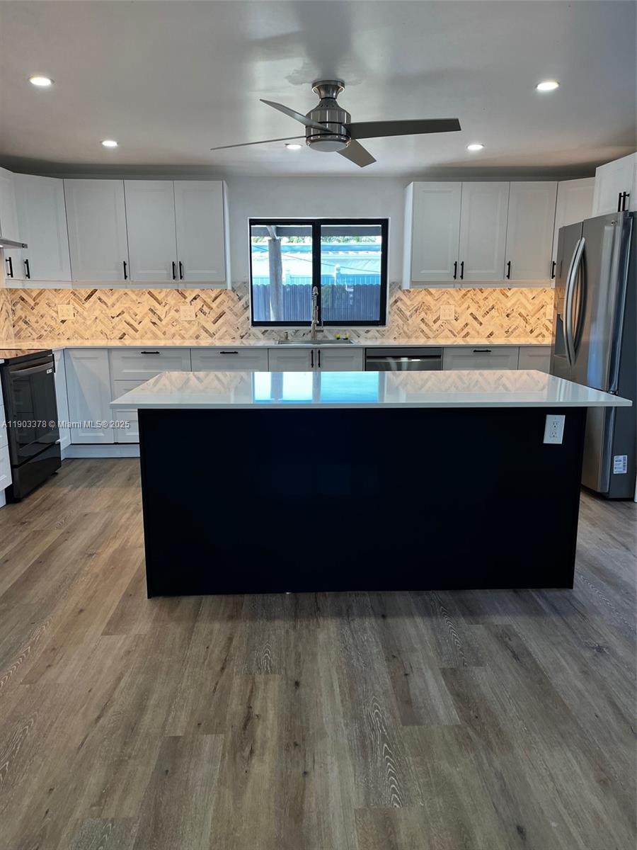 4640 Southwest 94th Court Miami, FL 33165 - Photo 9 of 37 a room with kitchen island granite countertop wooden floors and a large window