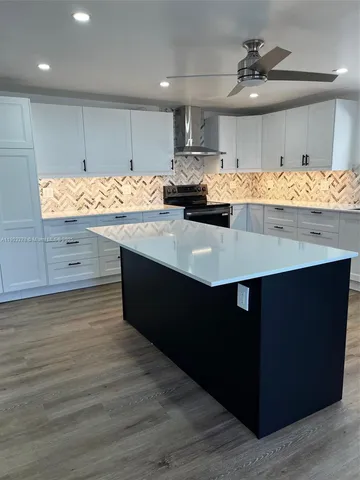 a kitchen with stainless steel appliances a sink dishwasher a refrigerator and cabinets with wooden floor