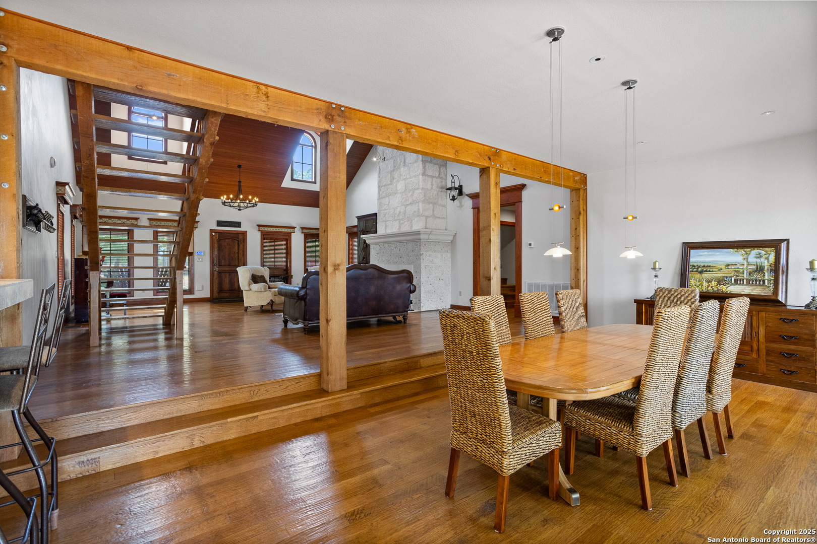 597 Krause Road Pipe Creek, TX 78063 - Photo 12 of 70 a dining room with wooden floor a chandelier a glass table and chairs