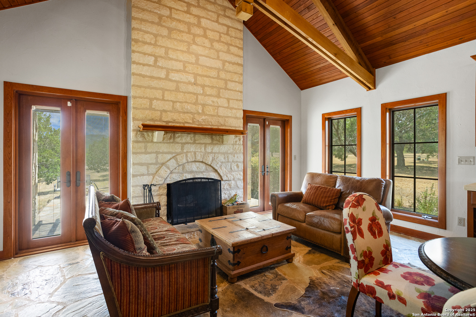 597 Krause Road Pipe Creek, TX 78063 - Photo 17 of 70 a living room with furniture a fireplace and a floor to ceiling window