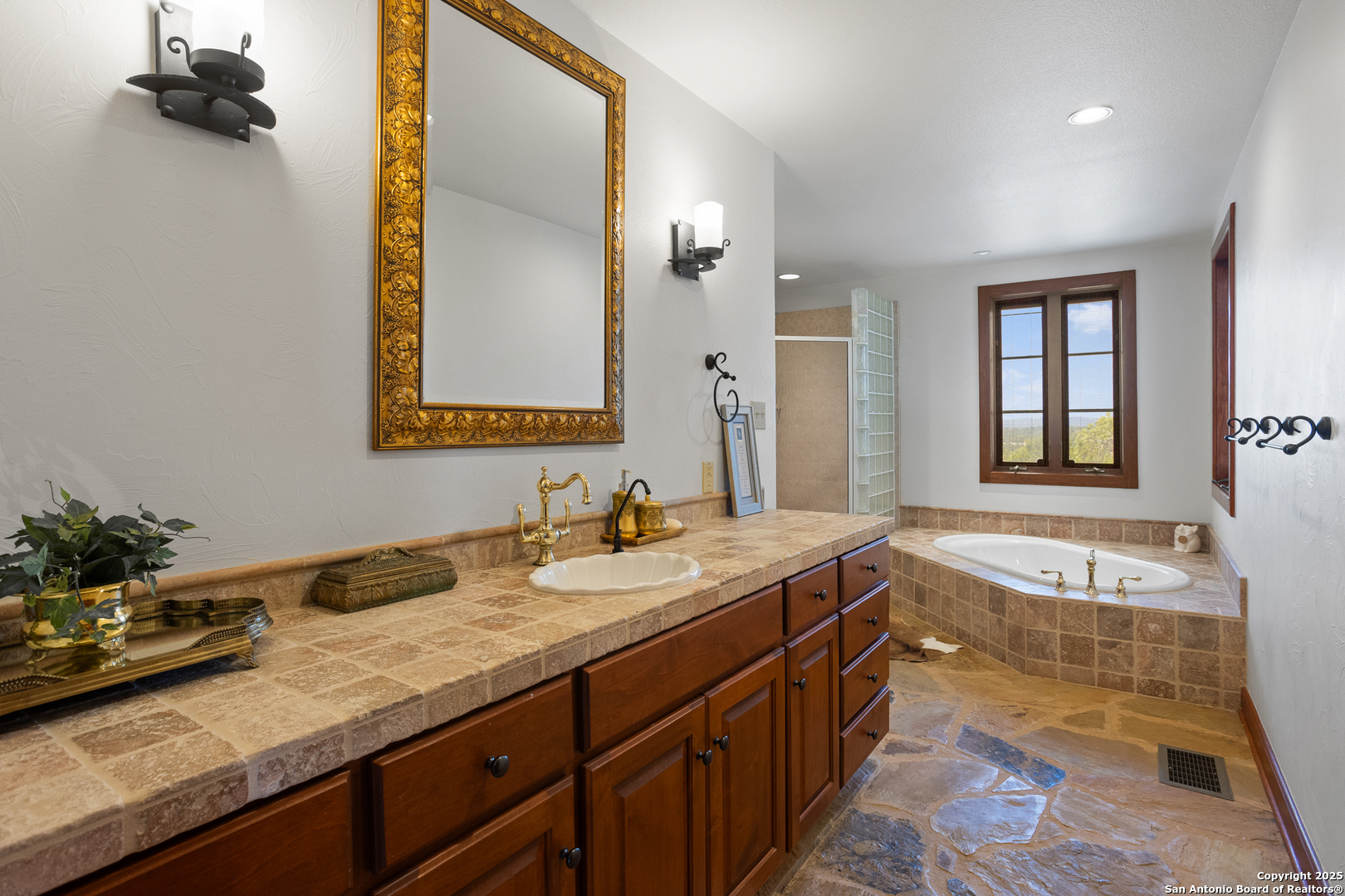 597 Krause Road Pipe Creek, TX 78063 - Photo 20 of 70 a bathroom with a granite countertop sink and a mirror