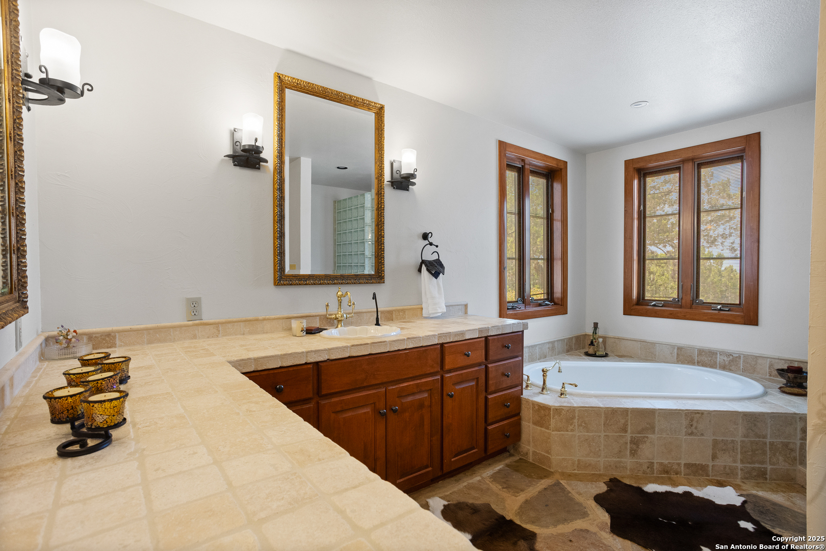 597 Krause Road Pipe Creek, TX 78063 - Photo 22 of 70 a bathroom with a tub sink and mirror
