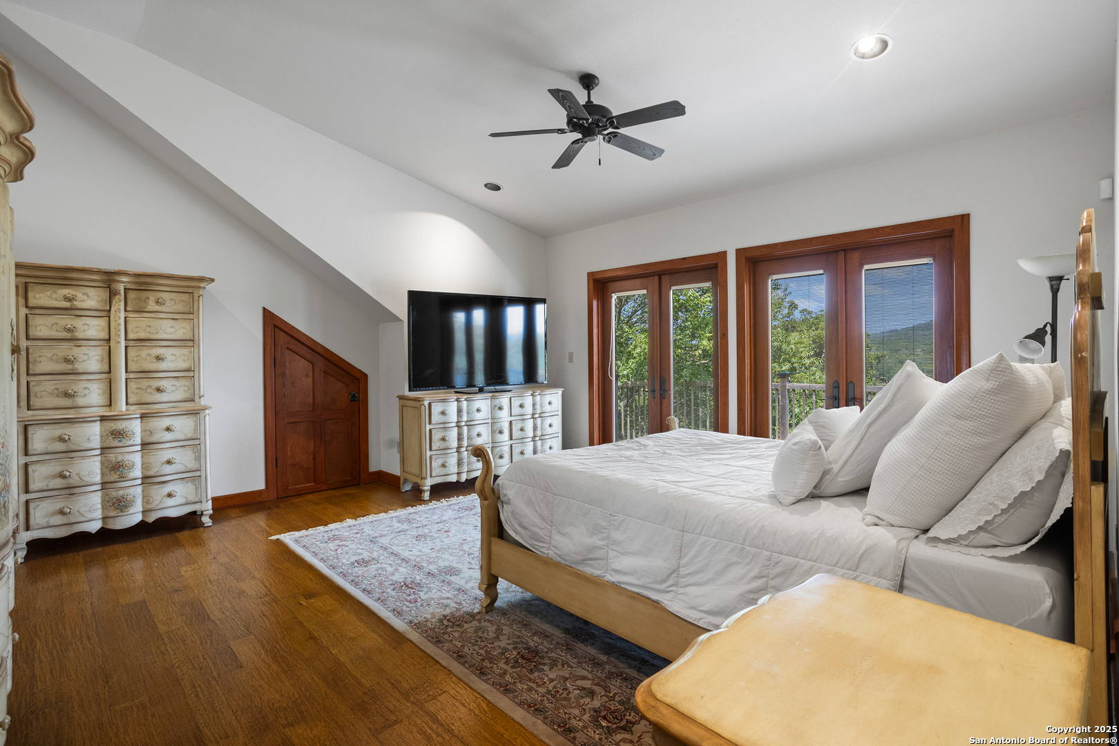 597 Krause Road Pipe Creek, TX 78063 - Photo 26 of 70 a bedroom with a large bed and a flat tv screen