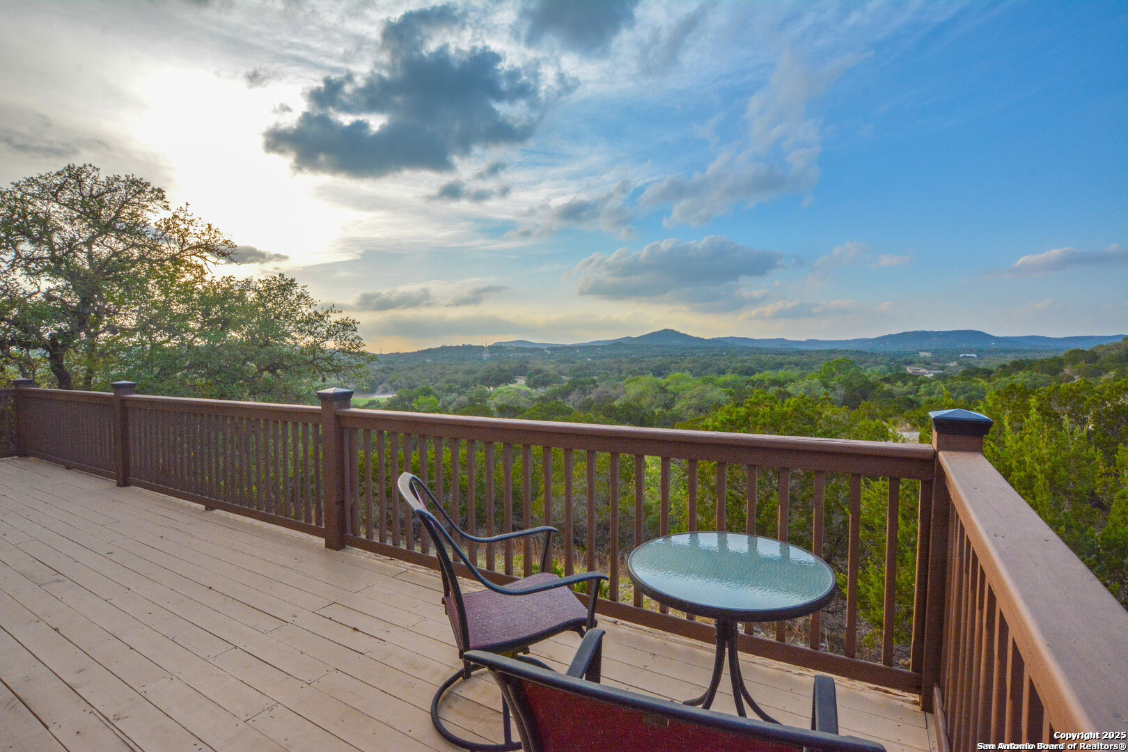 597 Krause Road Pipe Creek, TX 78063 - Photo 52 of 70 a balcony with wooden floor table and chairs