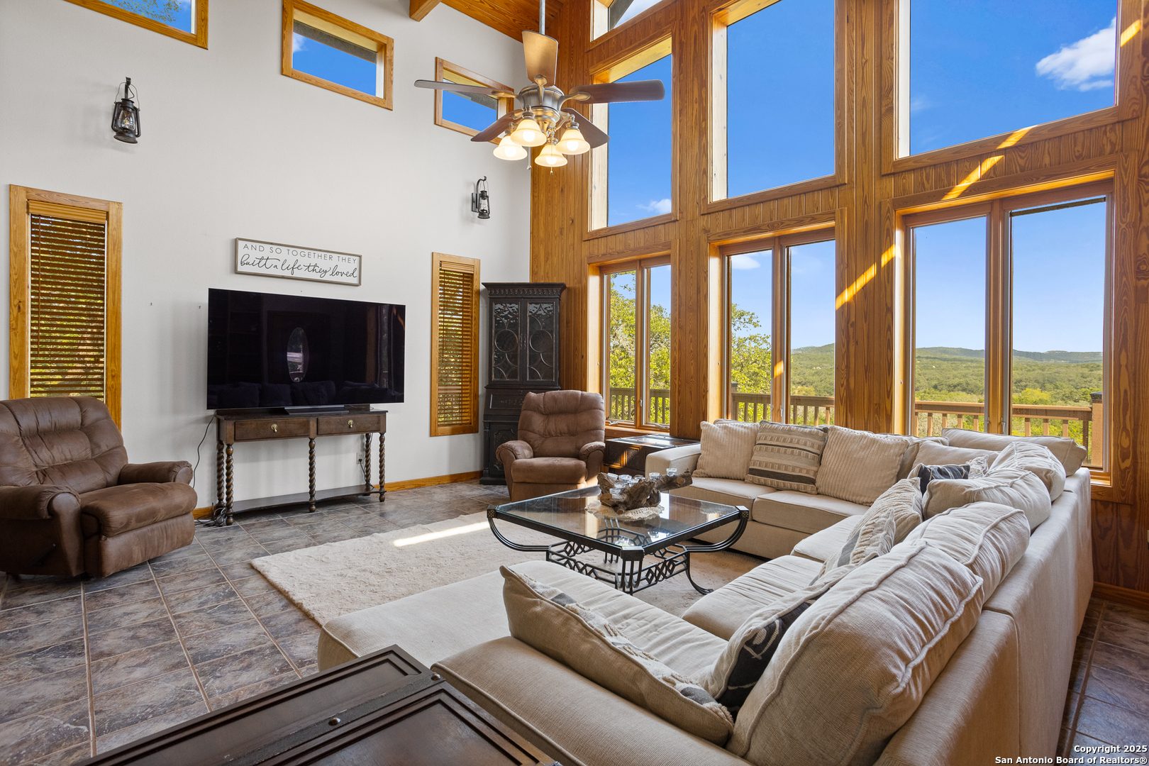 597 Krause Road Pipe Creek, TX 78063 - Photo 54 of 70 a living room with furniture a floor to ceiling window and a flat screen tv