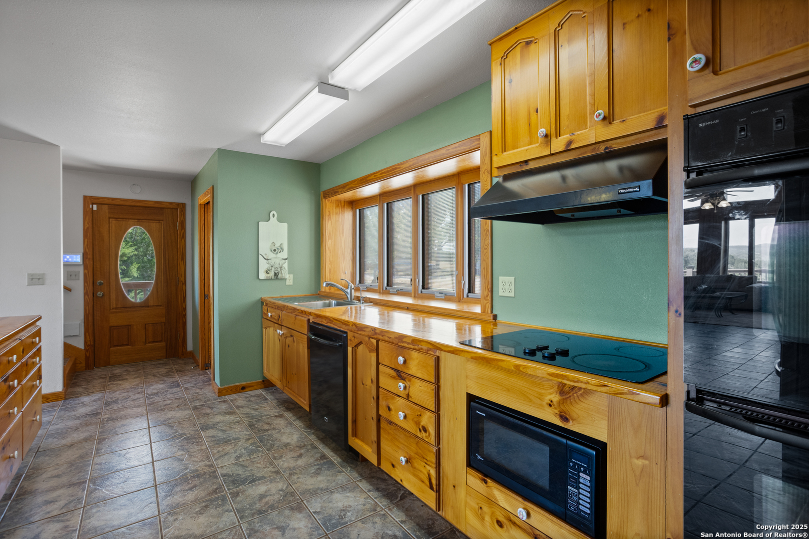 597 Krause Road Pipe Creek, TX 78063 - Photo 58 of 70 a kitchen with stainless steel appliances granite countertop a stove a sink and a microwave