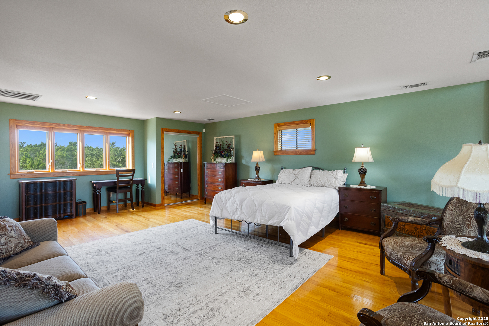 597 Krause Road Pipe Creek, TX 78063 - Photo 62 of 70 a spacious bedroom with a bed a couch and dresser