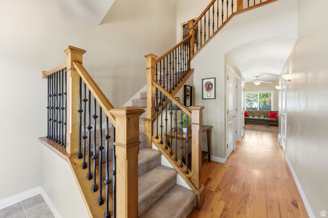 7235 Viansa Court Midvale, UT 84047 - Photo 3 of 43 Stairway with a ceiling fan, wood-type flooring, arched walkways, and a high ceiling