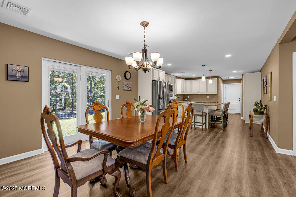 119 Darien Road Howell, NJ 07731 - Photo 11 of 47 a dining room with furniture a chandelier and wooden floor