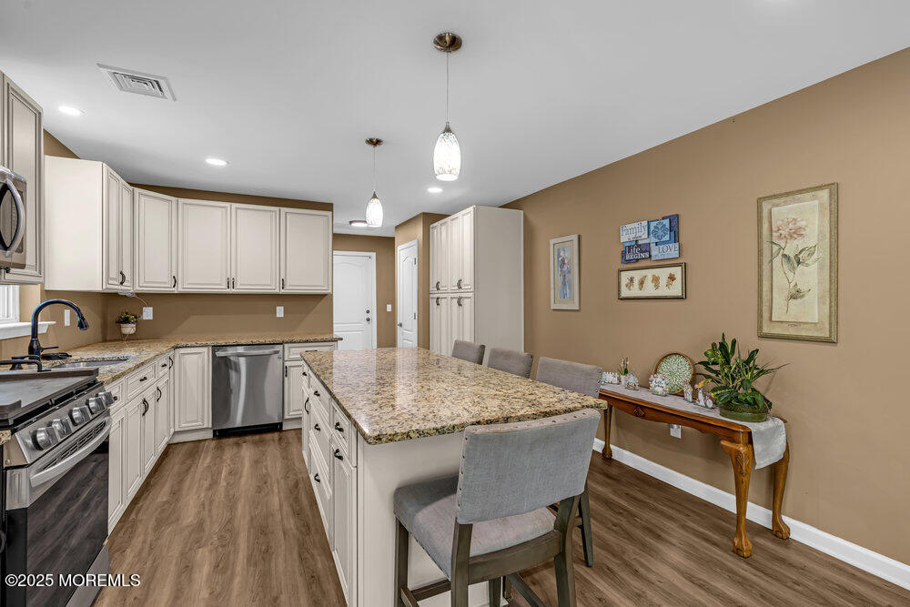 119 Darien Road Howell, NJ 07731 - Photo 16 of 47 a kitchen with granite countertop a stove a sink a dining table and chairs