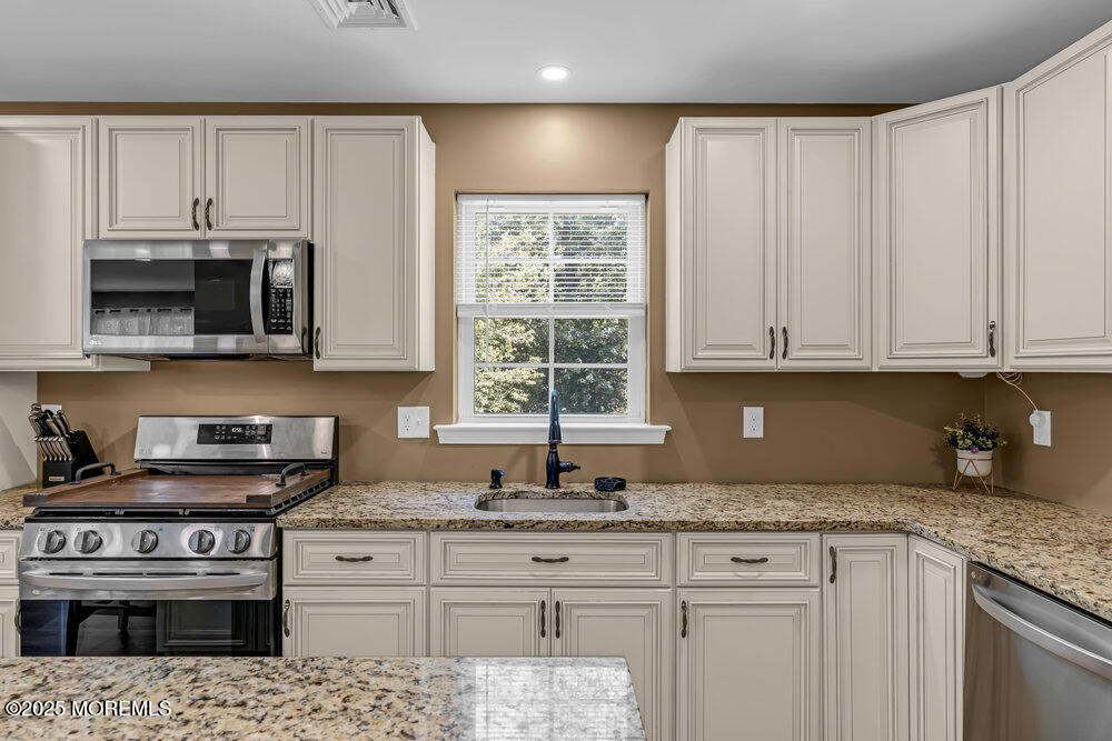 119 Darien Road Howell, NJ 07731 - Photo 20 of 47 a kitchen with stainless steel appliances granite countertop a stove a sink and a microwave