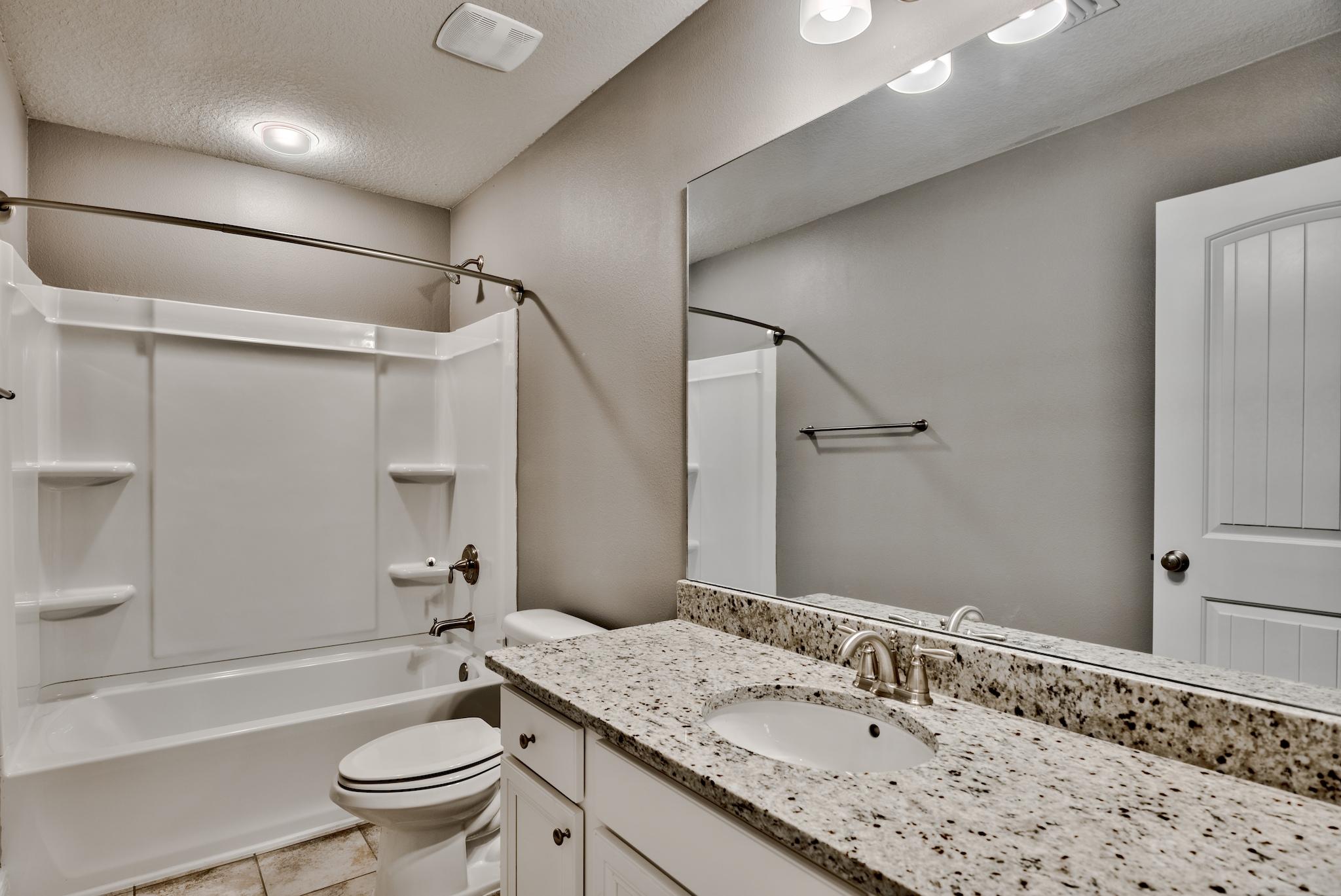 242 Pin Oak Loop Santa Rosa Beach, FL 32459 - Photo 22 of 43 a bathroom with a granite countertop sink toilet and shower