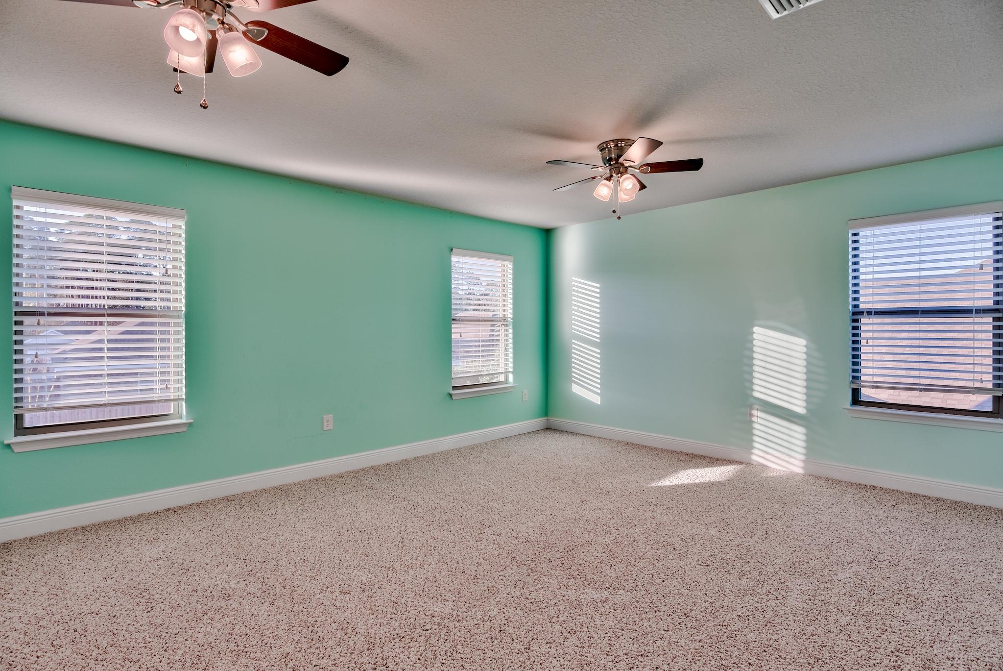 242 Pin Oak Loop Santa Rosa Beach, FL 32459 - Photo 27 of 43 a view of an empty room with windows and chandelier fan